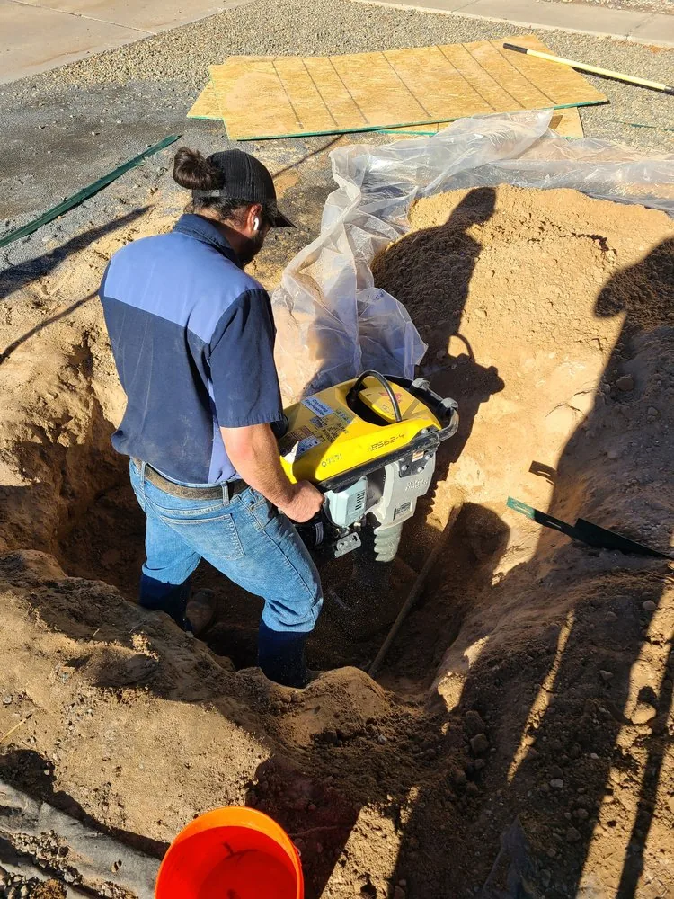 Above & Beyond plumber compacting dirt during a plumbing repair
